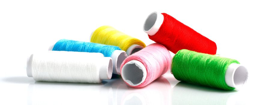 Set of colorful spools of thread isolated on white background