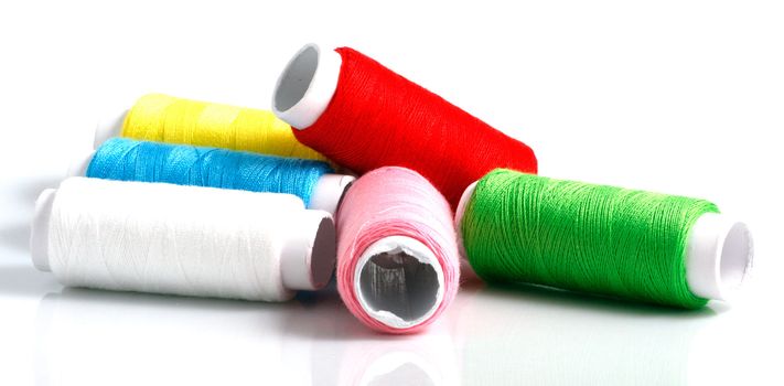 Set of colorful spools of thread isolated on white background