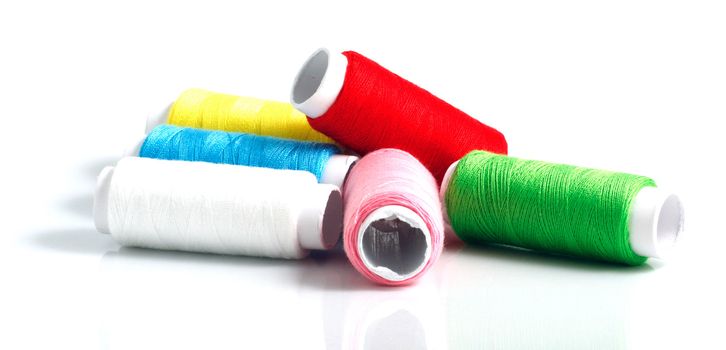 Set of colorful spools of thread isolated on white background