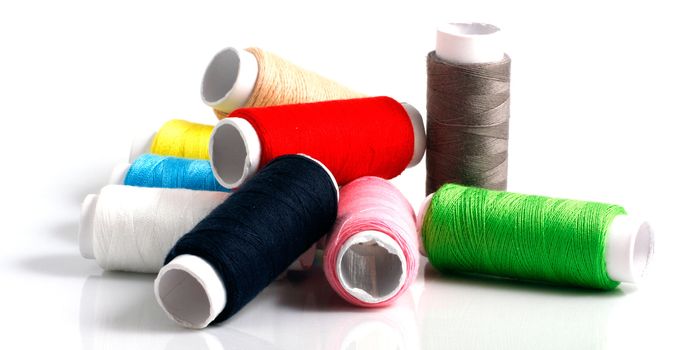 Set of colorful spools of thread isolated on white background