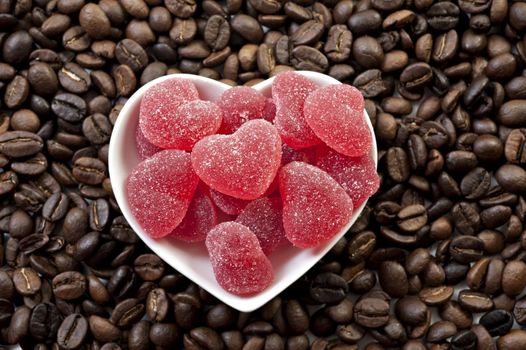 Red heart shaped jelly sweets and coffee bean background