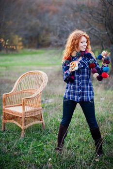 The red-haired girl in autumn leaves 
outdoor shot