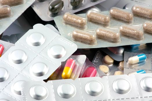 Pills of many shapes and colors grouped together