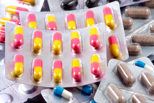 Pills of many shapes and colors grouped together