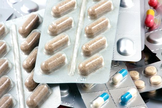 Pills of many shapes and colors grouped together