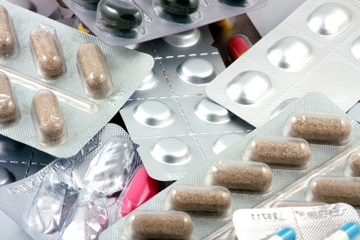 Pills of many shapes and colors grouped together