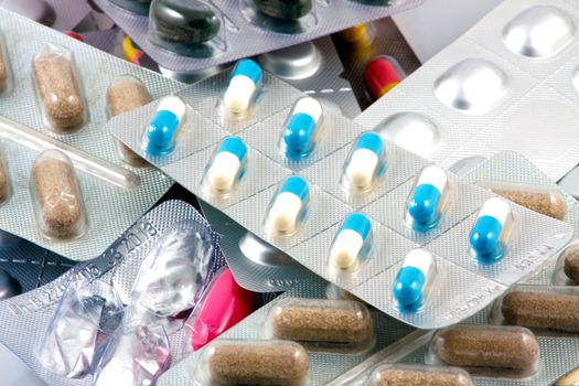 Pills of many shapes and colors grouped together