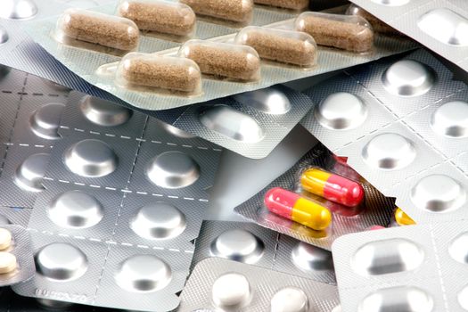 Pills of many shapes and colors grouped together