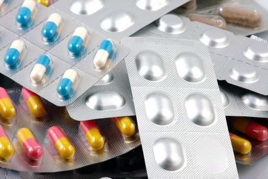 Pills of many shapes and colors grouped together