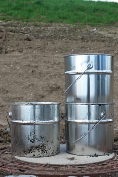 metal silver cans on ground on a building site