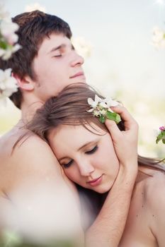 beautiful young couple kissing in the flowering gardens