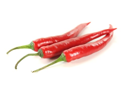 three red peppers on a white background