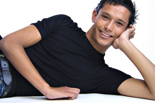 Studio portrait of mixed race young man lying down looking friendly