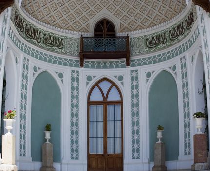 Facade of a palace with a balcony and an arch verandah with a rich ornament in the Italian style of XVI century 