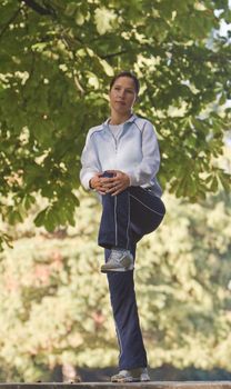 Woman doing warming up movements outdoors in a park.Shot with Canon 70-200mm f/2.8L IS USM
