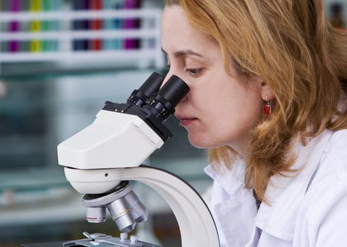 Female researcher looking through a microscope in a laboratory.Shot with Canon 70-200mm f/2.8L IS USM