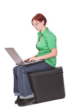 Redheaded girl working on a laptop.