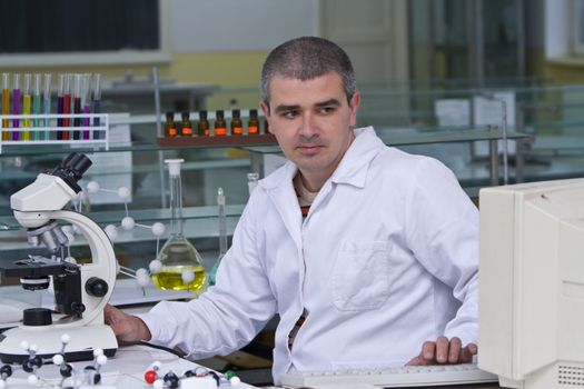 A researcher checking data on the computer computer at his workplace.SShot with Canon 70-200mm f/2.8L IS USM