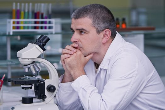 Researcher thinking at his workplace in a laboratory.Shot with Canon 70-200mm f/2.8L IS USM