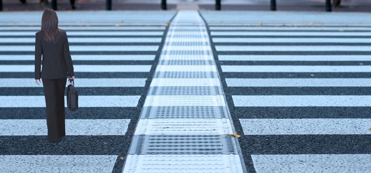 Image of a businesswoman crossing the street.