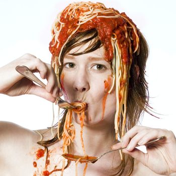 Portrait of a young girl eating spaghetti of her head