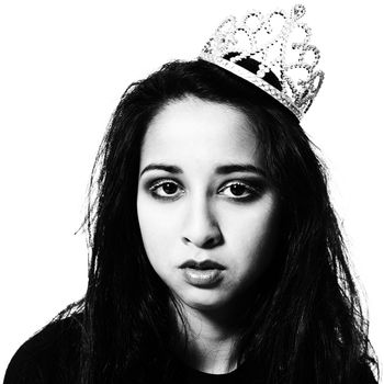 Studio portrait of an asian mixed raced teenager with a beauty queen crown looking depressed