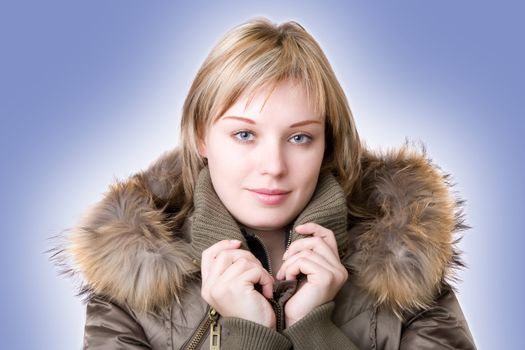 young girl in a jacket with a fur collar on a light blue background