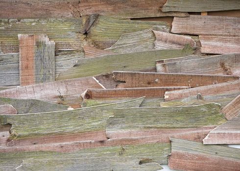 An old shed repaired with pieces of broken wooden planks.