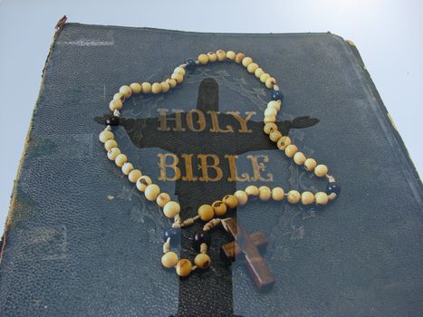 A composite of two photos taken by the author - a rosary on an antique Bible and Corcovado (statue of Christ in Rio de Janeiro, Brazil). 