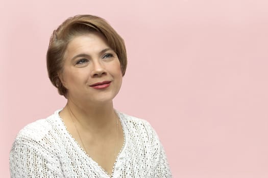 Portrait of the middle-aged woman on a pink background