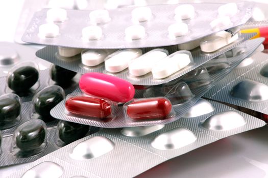 Pills of many shapes and colors grouped together