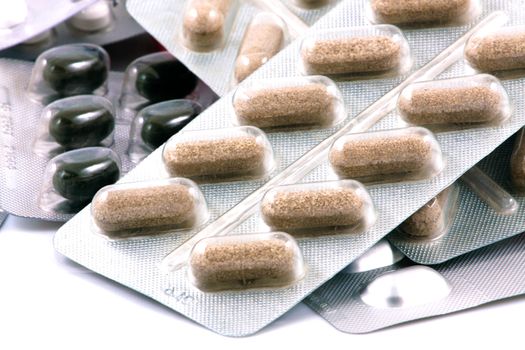 Pills of many shapes and colors grouped together