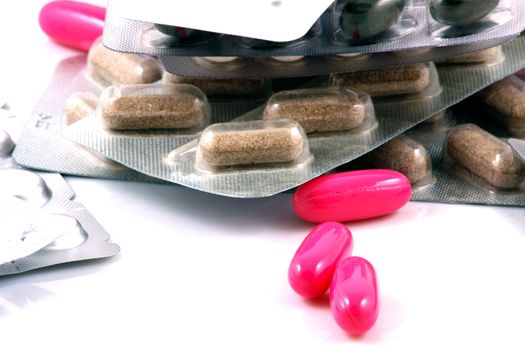 Pills of many shapes and colors grouped together