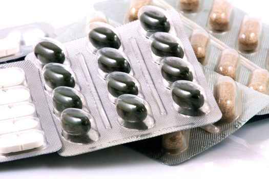 Pills of many shapes and colors grouped together