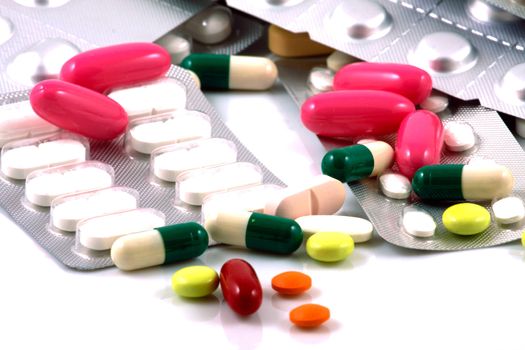 Pills of many shapes and colors grouped together