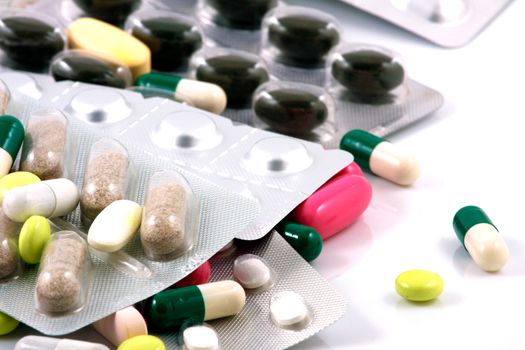 Pills of many shapes and colors grouped together