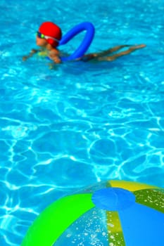 A colorful beach ball floating on the swimming pool.