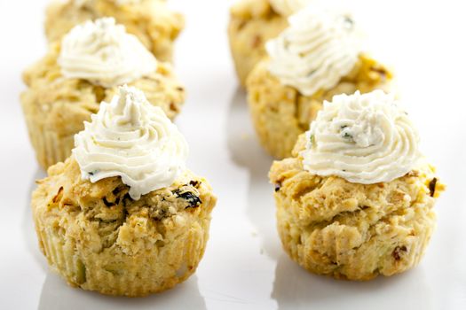 Savory bread muffins topped with creamy cheese.