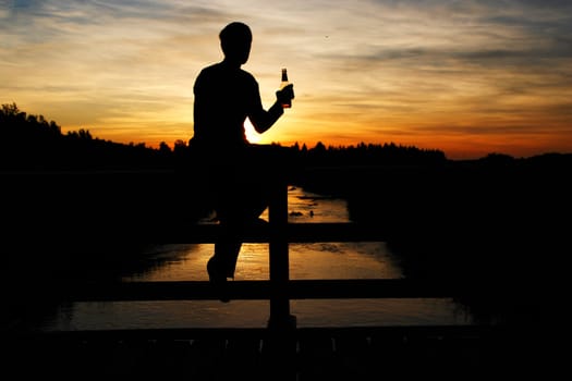 A person sitting on a bridge and listening to the music