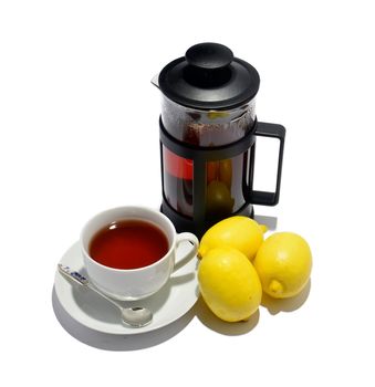 Cup of tea, kettle and three lemons isolated on white