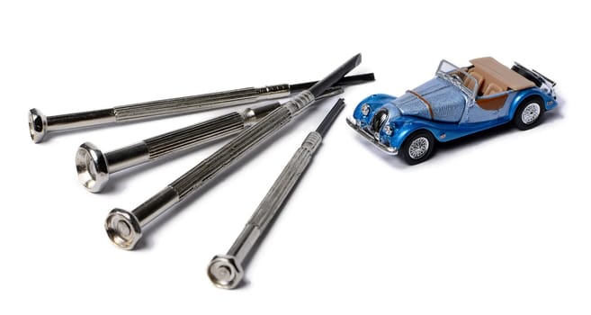miniature car and a screwdrivers isolated on white