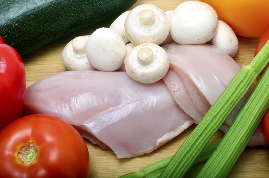 chicken and vegetables on a cutting board, closeup