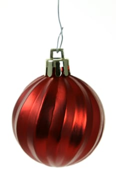 A single isolated red Christmas bauble hanging. (focus on middle of bauble)
