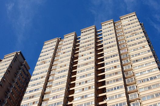 Bottom view of modern apartment buildings against blue sky