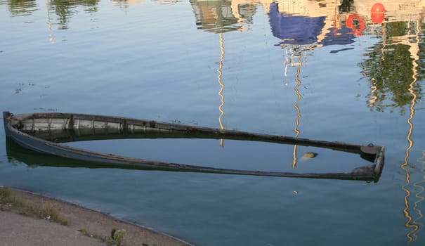 The flooded boat on a background of reflections of masts.