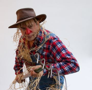 Scarecrow looks menacing holding a pitchfork.