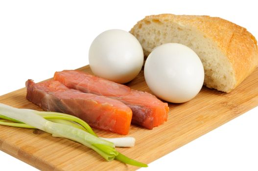 Light breakfast. Eggs, salted salmon, muffin and onion on a wooden board. Isolated on white.