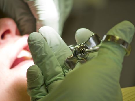 A woman gets an injection at the dentist's office before having a root canal. The syringe is in focus, with the patient in the background