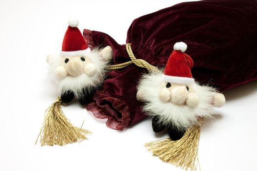 Santa Claus toy and fancy luxury gift bag over white background 