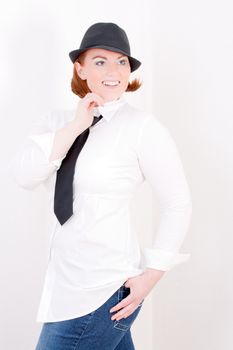 Fashionable red-haired woman wearing a hat and tie